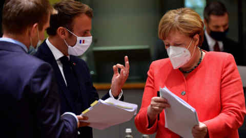 German Chancellor Angela Merkel looks on next to French President Emmanuel Macron during an EU summit in Brussels on July 20, 2020, as the leaders of the European Union hold their first face-to-face summit over a post-virus economic rescue plan. (Photo by JOHN THYS / POOL / AFP) (Photo by JOHN THYS/POOL/AFP via Getty Images)