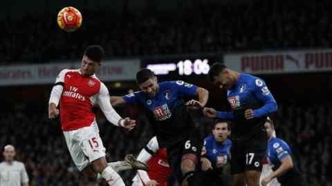 Arsenal's English midfielder Alex Oxlade-Chamberlain (L) jumps to win the ball from Bournemouth's South African-born English midfielder Andrew Surman and Bournemouth's Norwegian striker Joshua King (R) during the English Premier League football match between Arsenal and Bournemouth at the Emirates Stadium in London on December 28, 2015. AFP PHOTO / ADRIAN DENNIS RESTRICTED TO EDITORIAL USE. No use with unauthorized audio, video, data, fixture lists, club/league logos or 'live' services. Online in-match use limited to 75 images, no video emulation. No use in betting, games or single club/league/player publications. / AFP / ADRIAN DENNIS (Photo credit should read ADRIAN DENNIS/AFP/Getty Images)