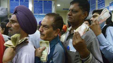 Indian bank customers wait to deposit 500 and 1000 Indian currency notes at a bank in  Amritsar on November 10, 2016. 
Long queues formed outside banks in India as they reopened for the first time since the government's shock decision to withdraw the two largest denomination notes from circulation. / AFP PHOTO / NARINDER NANUNARINDER NANU/AFP/Getty Images