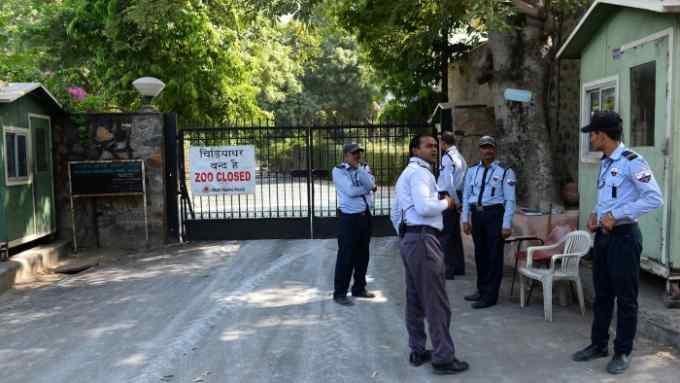 Indian private security guards stand near a banner placed at the main gate of the Delhi zoo in New Delhi on October 19, 2016. New Delhi zoo has temporarily closed after two birds died of bird flu, its curator said October 19, a month after India declared itself free of the disease.Â Riaz Khan said tests had confirmed the birds died ofÂ the H5 strain of avian influenza, commonly known as bird flu. &quot;We have shut the zoo down only for two to four days to conduct tests and monitor the situation to see it does not spread,&quot; Khan told AFP.Â  / AFP / SAJJAD HUSSAIN (Photo credit should read SAJJAD HUSSAIN/AFP/Getty Images)