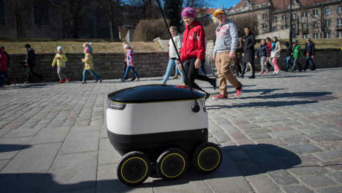 Self Driving Delivery Robot By Starship Technologies Aims To Revolutionise Parcel Delivery...Schoolchildren watch as a prototype self driving parcel delivery robot, developed by Starship Technologies, drives past them in the city center in Tallinn, Estonia, on Tuesday, April 12, 2016. The electric-powered robots intend to help short-range low cost deliveries and ultimately aim to make the local delivery of goods free. Photographer: Peti Kollanyi/Bloomberg