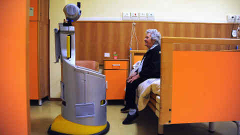 A robot of the project Robot-Era goes to take a lady in the room to accompany her in the dining room at nursing residence San Lorenzo on December 19, 2015 in Florence, Italy