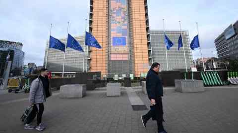 People walk past the European Commission building in Brussels. Instead of yet more rules, the EU needs a central treasury able to raise taxes and commit spending on Europe-wide public goods
