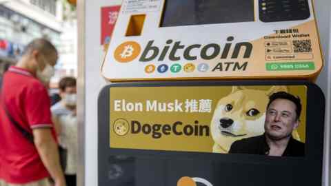 A Dogecoin advertising sticker appears on a cryptocurrency ATM at a laundromat in Hong Kong, China