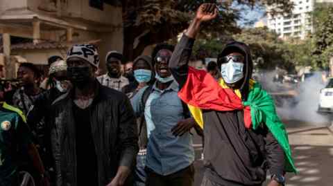 Protesters gesture after police fired teargas at them outside the General Assembly in Plateau, Dakar