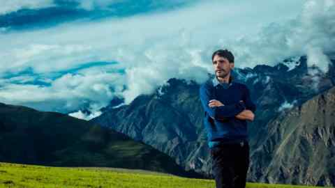 Chef Virgilio Martínez stands on a hillside against a background of mountains