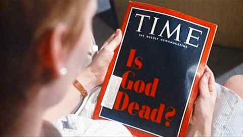 A person holding a Time magazine, with its front cover asking ‘Is God Dead?’