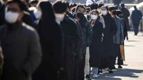 A photo of people wearing face masks queuing at a Covid testing centre in Seoul, South Korea
