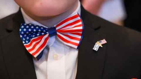 Um homem usando uma gravata-borboleta com a cor da bandeira americana espera pela chegada de Donald Trump em uma festa de observação da noite eleitoral em seu resort em Mar-a-Lago, em Palm Beach, Flórida.