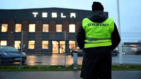 An IF Metall union member stands outside a Tesla service center