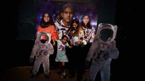 A mother and her daughter arrive at Nehru Planetarium in New Delhi to watch India’s Moon landing