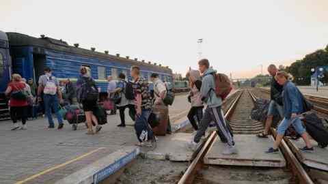 Ukrainian citizens from Russian-occupied Ukrainian territories board a train to Kyiv at the train station after a night in an humanitarian centre for Ukrainian internally displaced persons